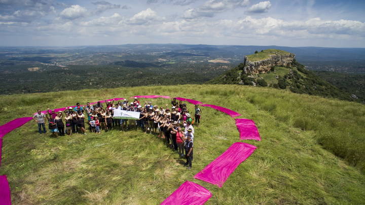 Los viajeros instalan un lazo gigante rosa en las Tetas de Viana en solidaridad con el cáncer de mama