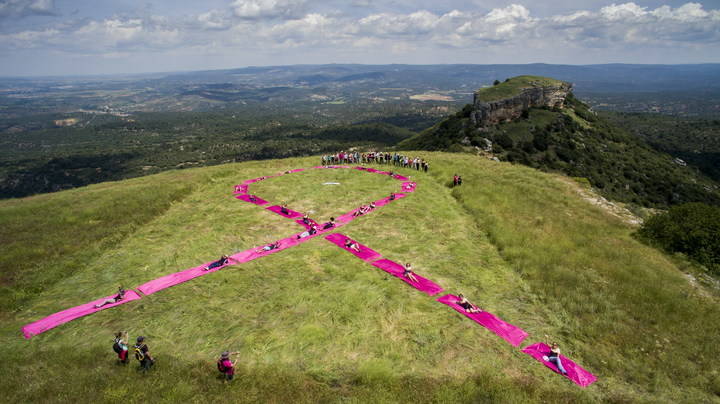 Los viajeros instalan un lazo gigante rosa en las Tetas de Viana en solidaridad con el cáncer de mama