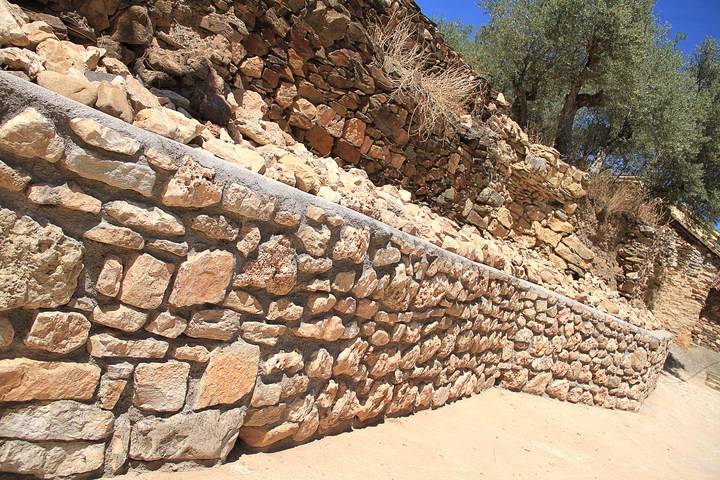Un muro de mampostería remata el urbanismo en el entorno deportivo de Muriel