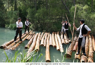 Los gancheros navegando sobre los troncos